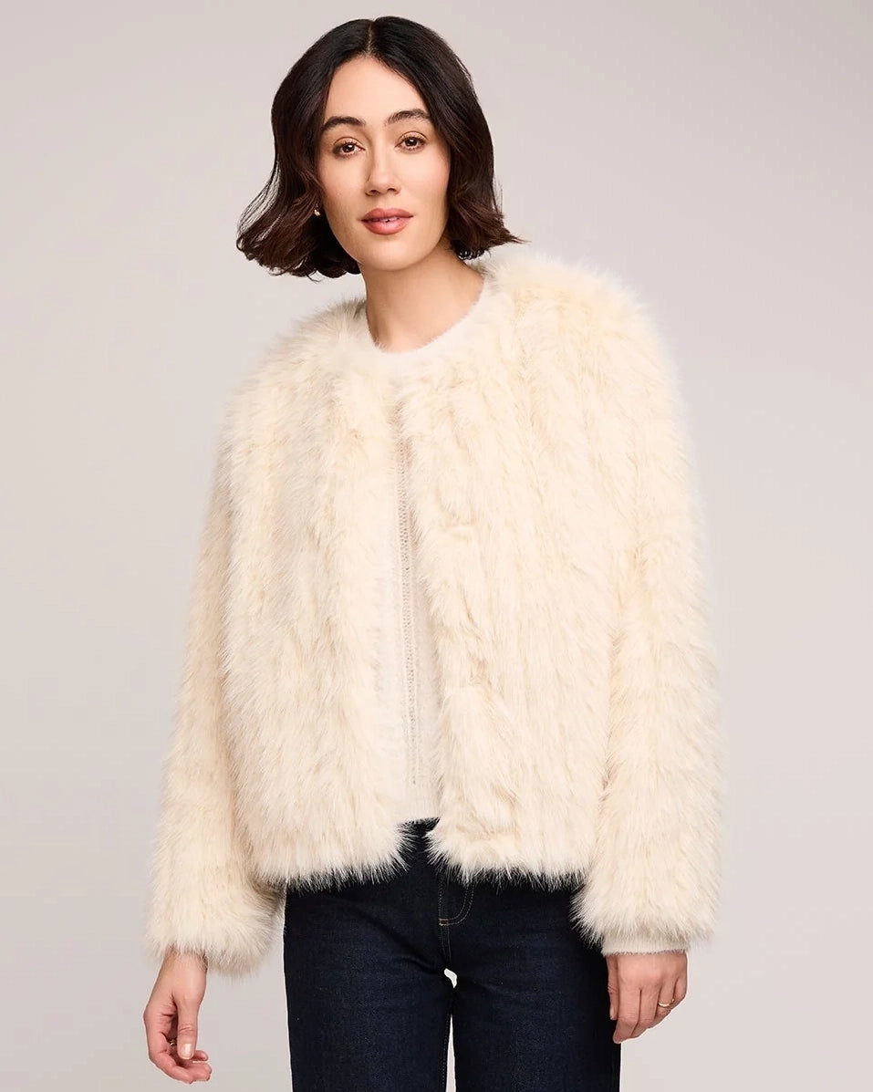 woman wearing a faux fur jacket in cream