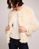 woman wearing a faux fur jacket in cream