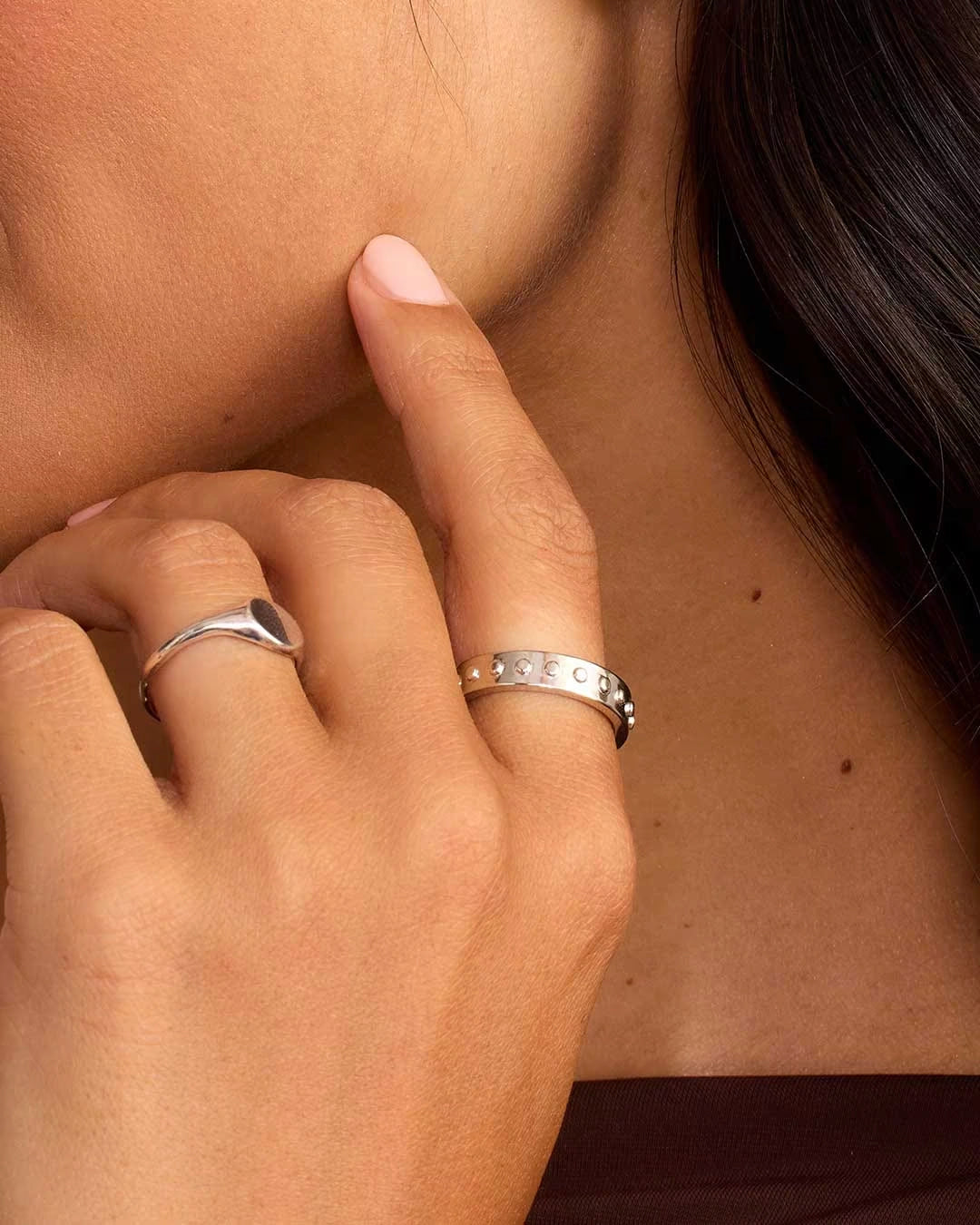 A silver-plated band ring with metallic silver studs and a textured surface.