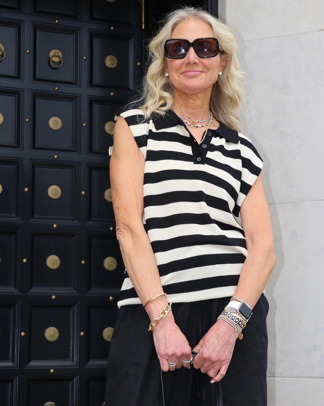 Woman wearing a black and white striped sleeveless knit top
