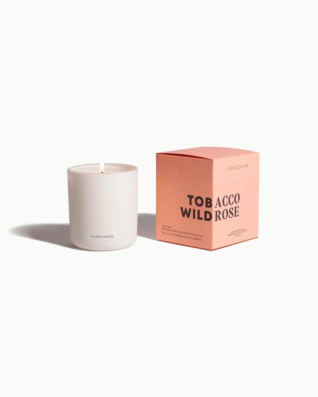 White candle with a pink box labeled 'Tobacco Wild Rose' by Homecoming