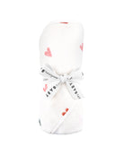 A children's hooded towel with a heart pattern on it wrapped up for gifting