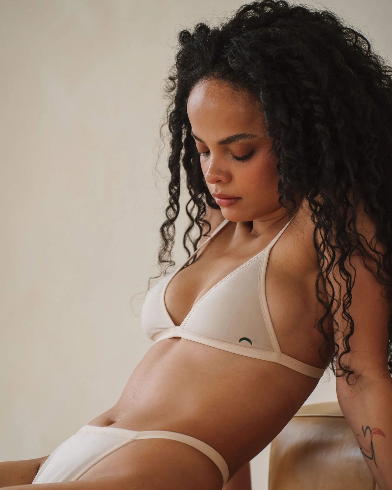 a woman wears a beige string triangle bralette with thin straps by Huha