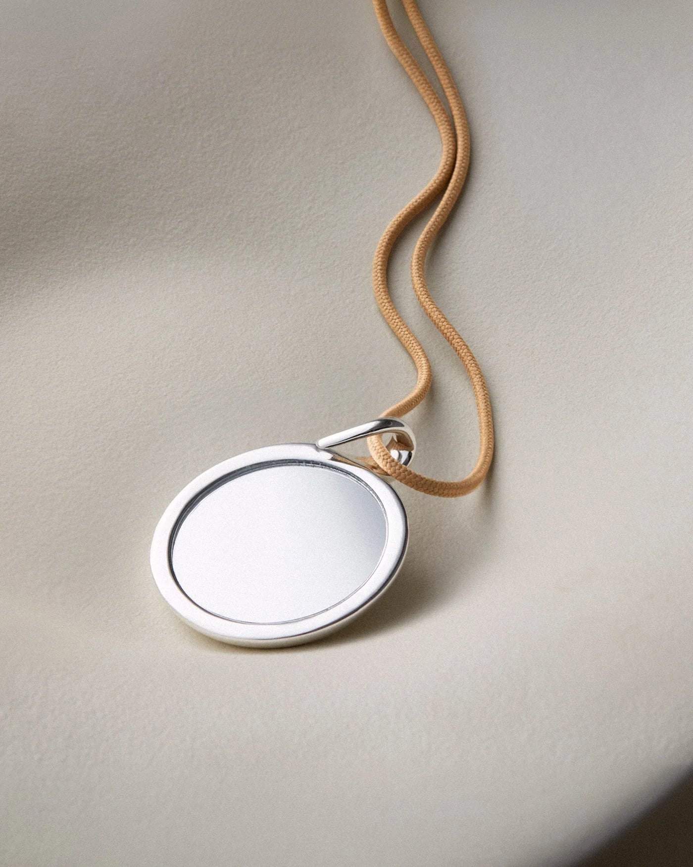 tan cord necklace with a chunky silver pendant