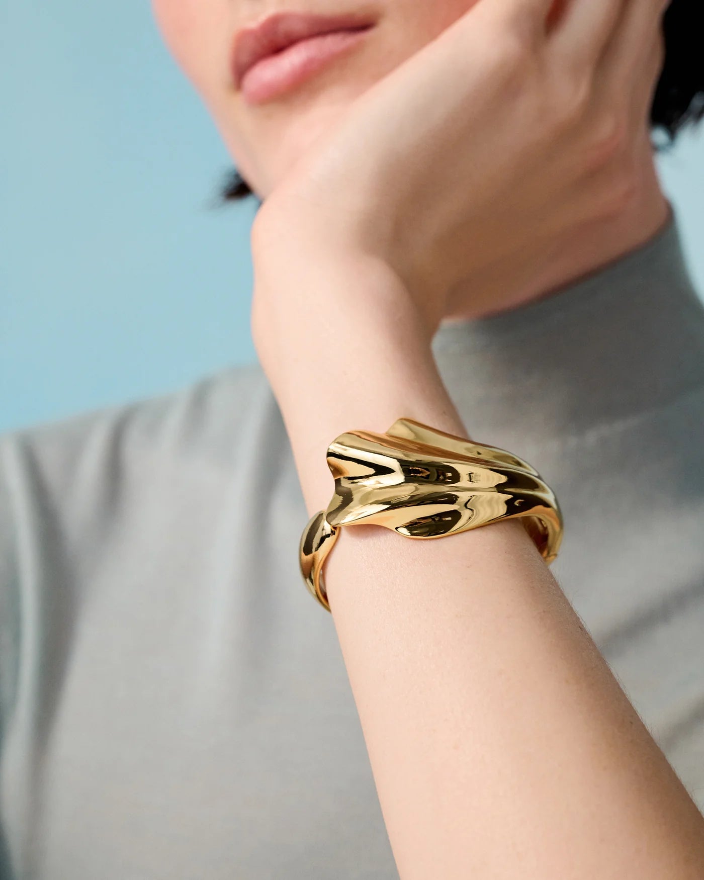 woman wearing Gold solid cuff bracelet with a wavy design