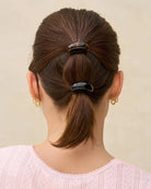 Back view of a person with brown hair tied in a ponytail using a Black and tortoiseshell cloud-shaped hair cuffs