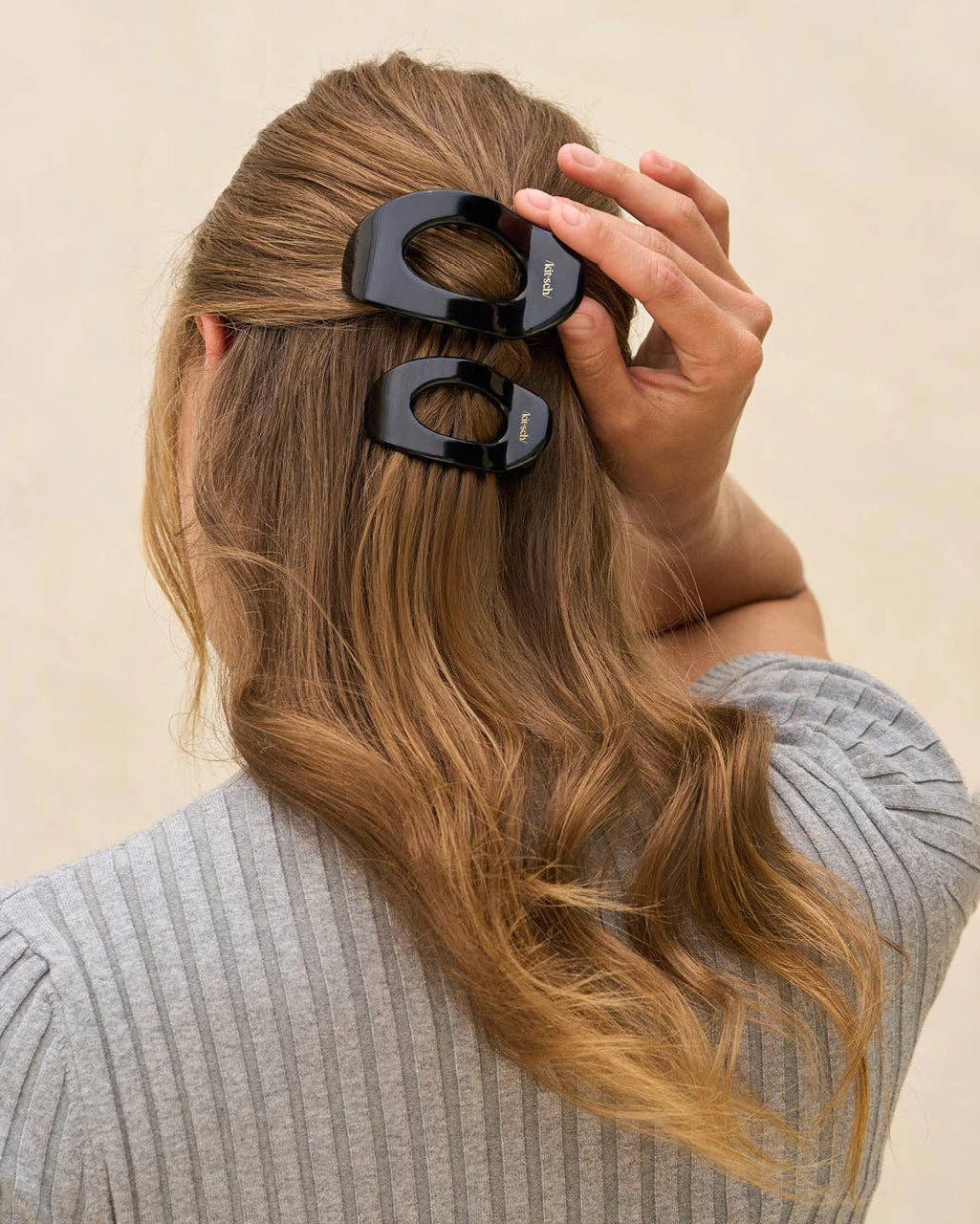 woman wearing black hair clip with 'kitsch' branding