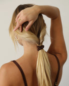 view of a person with brown silk scrunchie ponytail