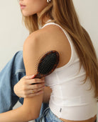 woman holding a Tortoiseshell hairbrush with black bristles