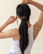 Curly hair tied back with a brown silk scrunchie