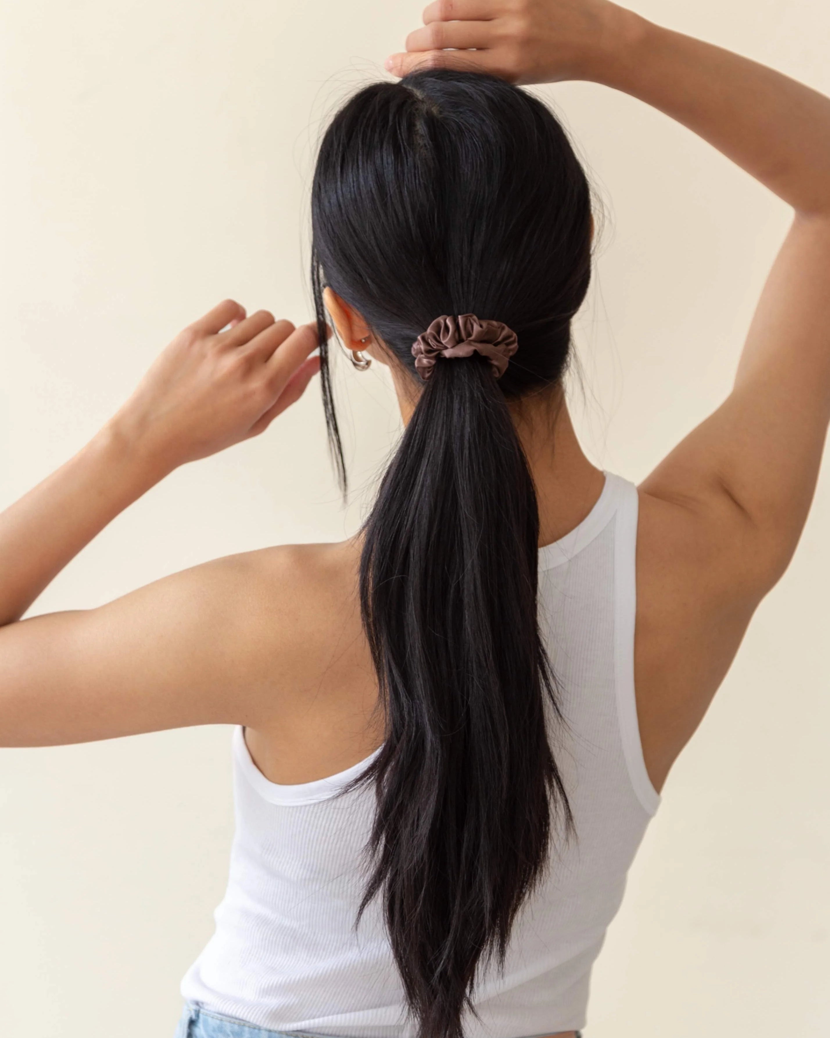 Curly hair tied back with a brown silk scrunchie