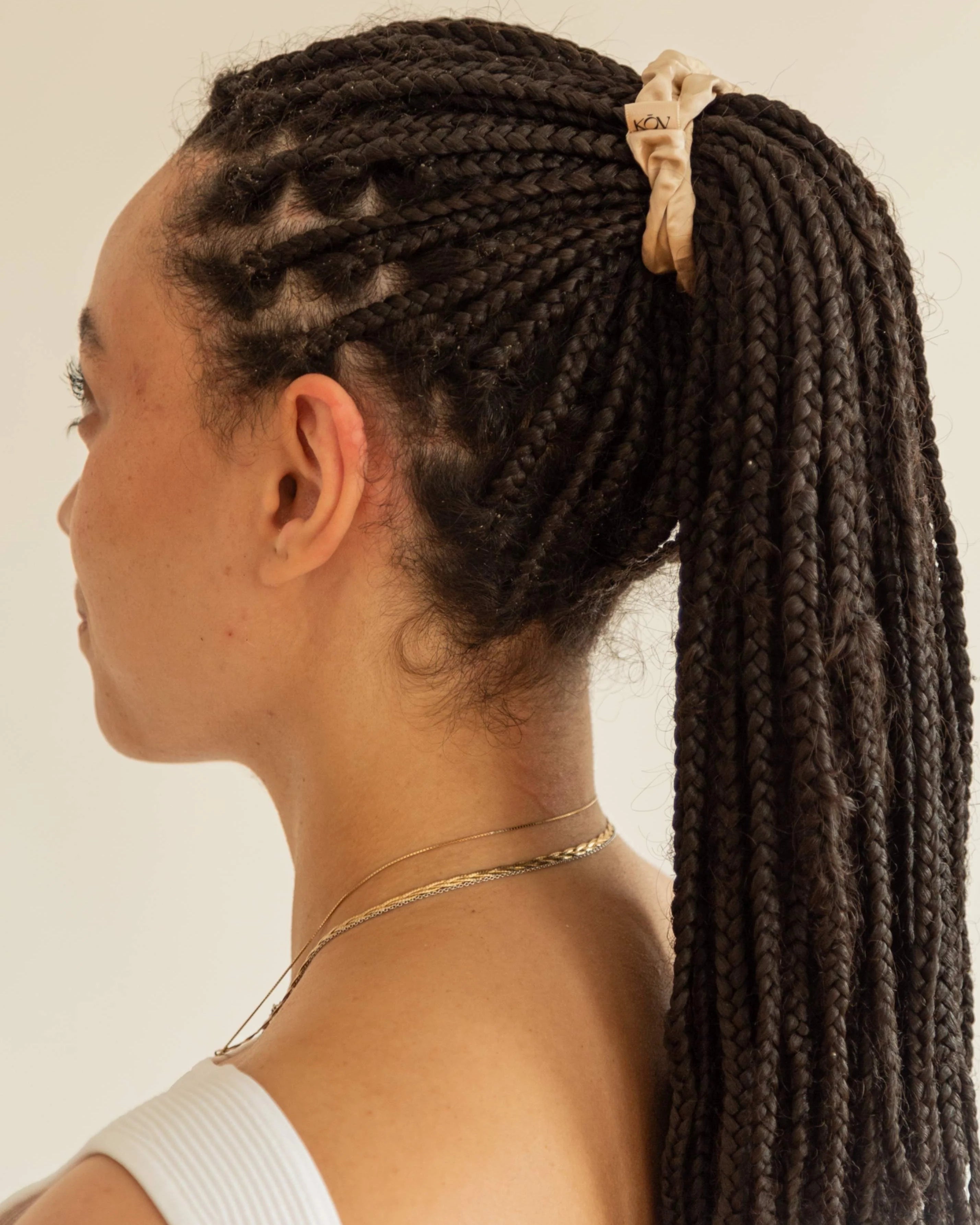 Curly hair tied back with a beige silk scrunchie