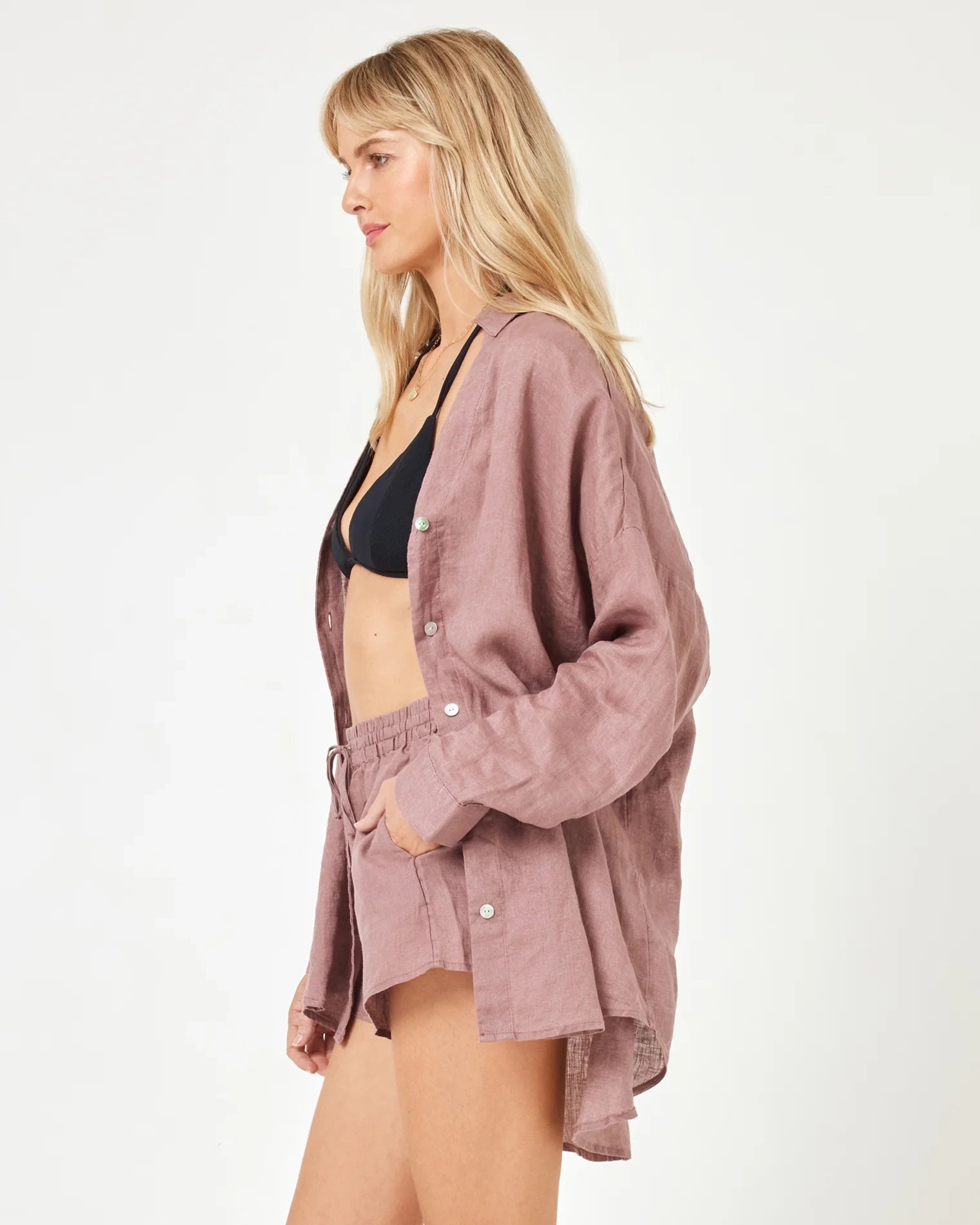 A model wearing smoky quartz-colored linen shorts with an adjustable tie waist and matching shirt