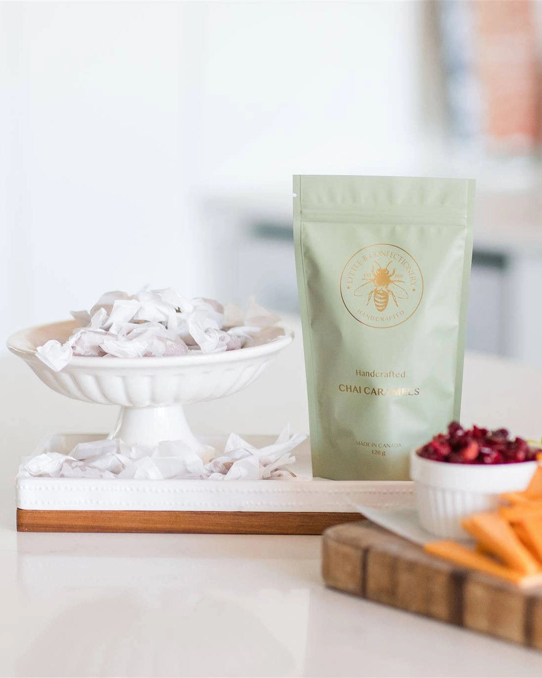 Green package of chai caramels by Little B Confectionary caramels with a bowl of caramels