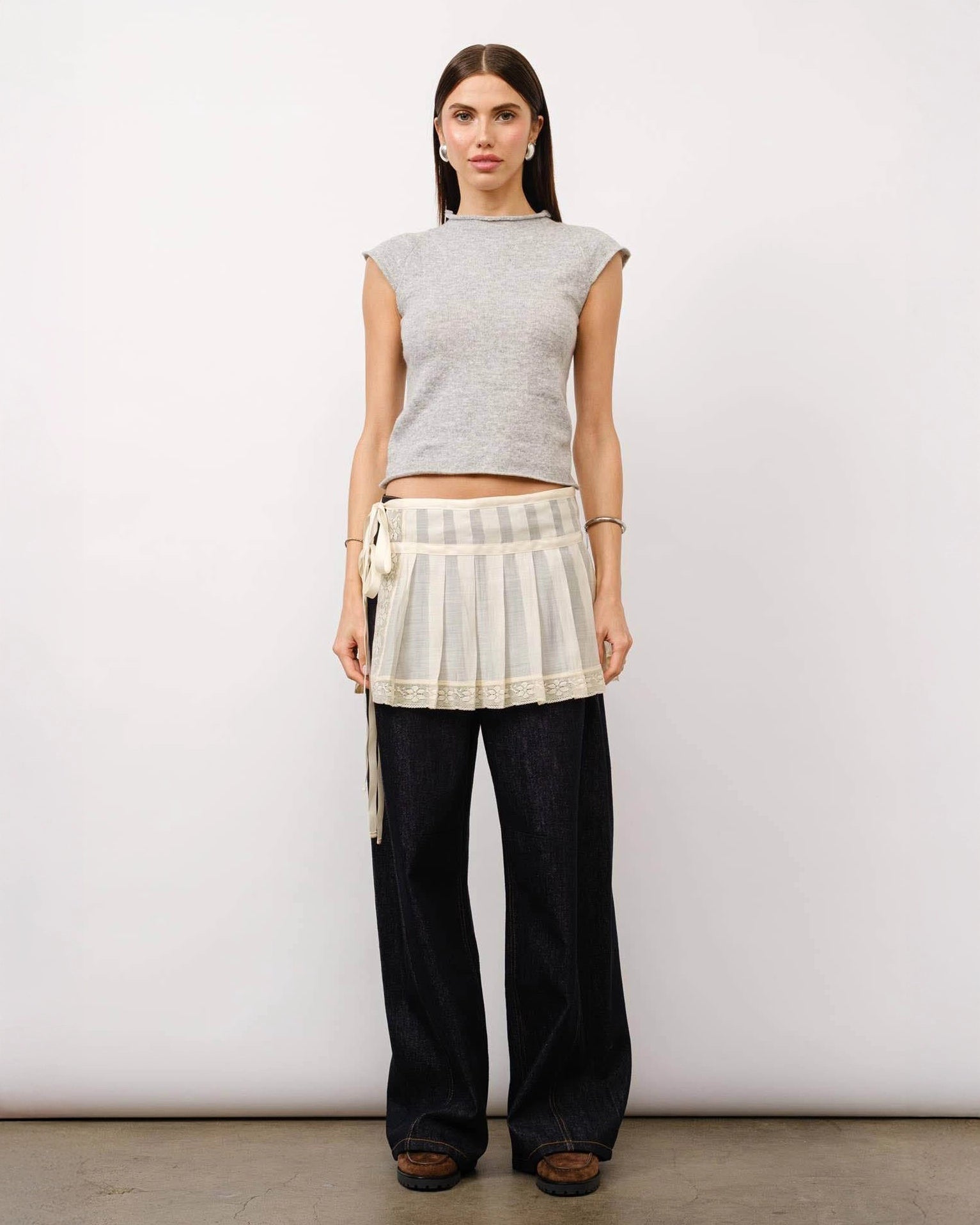 A model wearing a grey melange cap sleeve top with a fitted silhouette