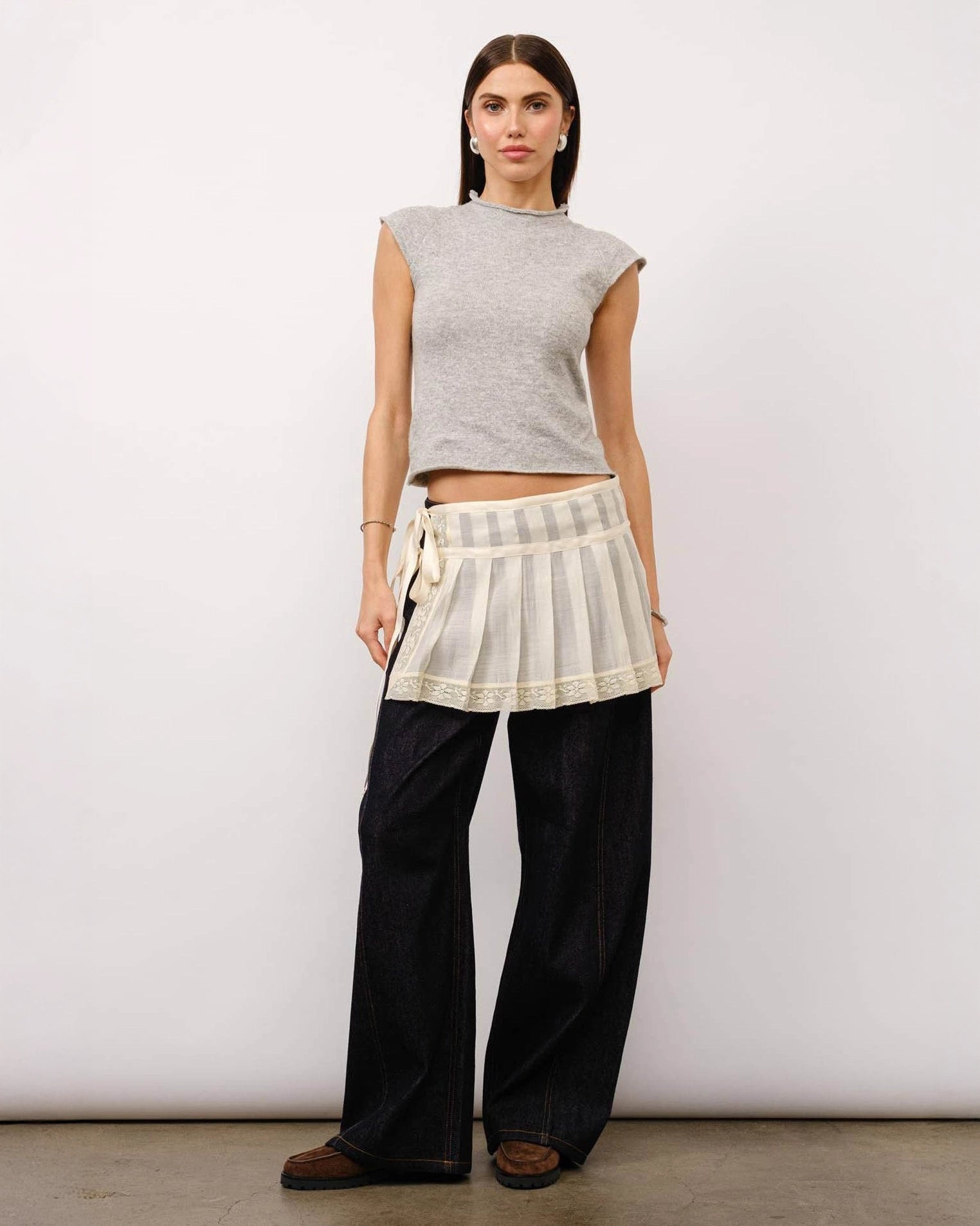 A model wearing a grey melange cap sleeve top with a fitted silhouette