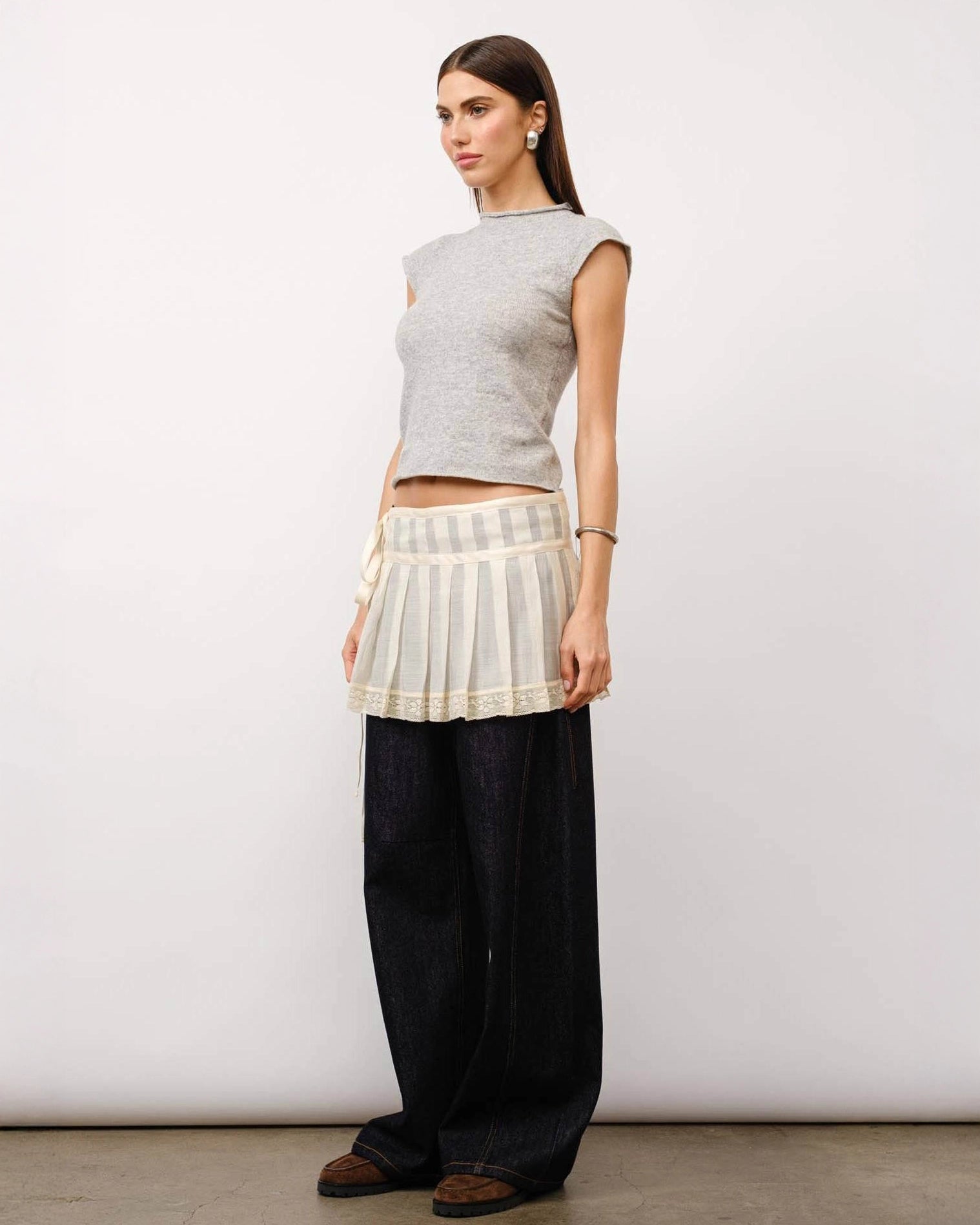 A model wearing a grey melange cap sleeve top with a fitted silhouette