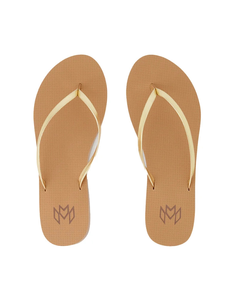 A pair of tan flip flops with metallic gold straps, viewed from above.