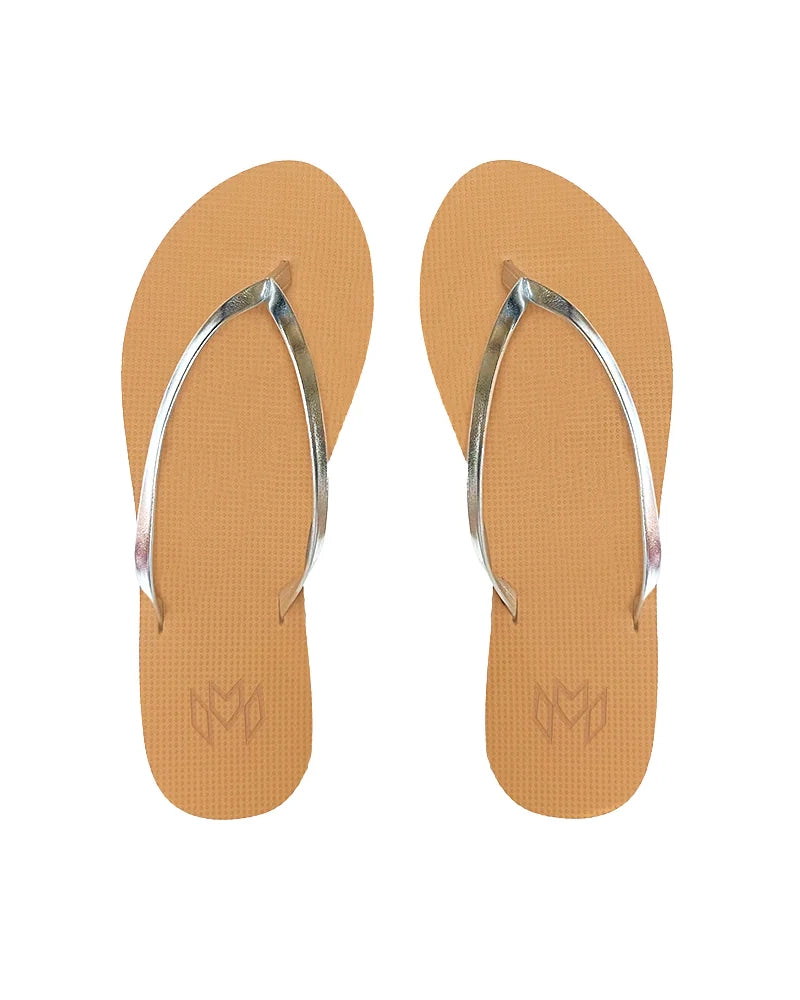 A pair of tan flip flops with metallic silver straps, viewed from above.