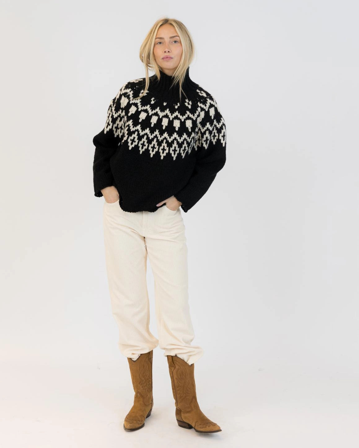 Woman wearing a fairisle sweater in blavk with cream accents