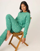 Woman wearing a green pajama set with white bears embroidered all over