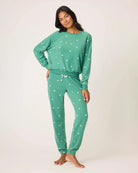 Woman wearing a green pajama set with white bears embroidered all over