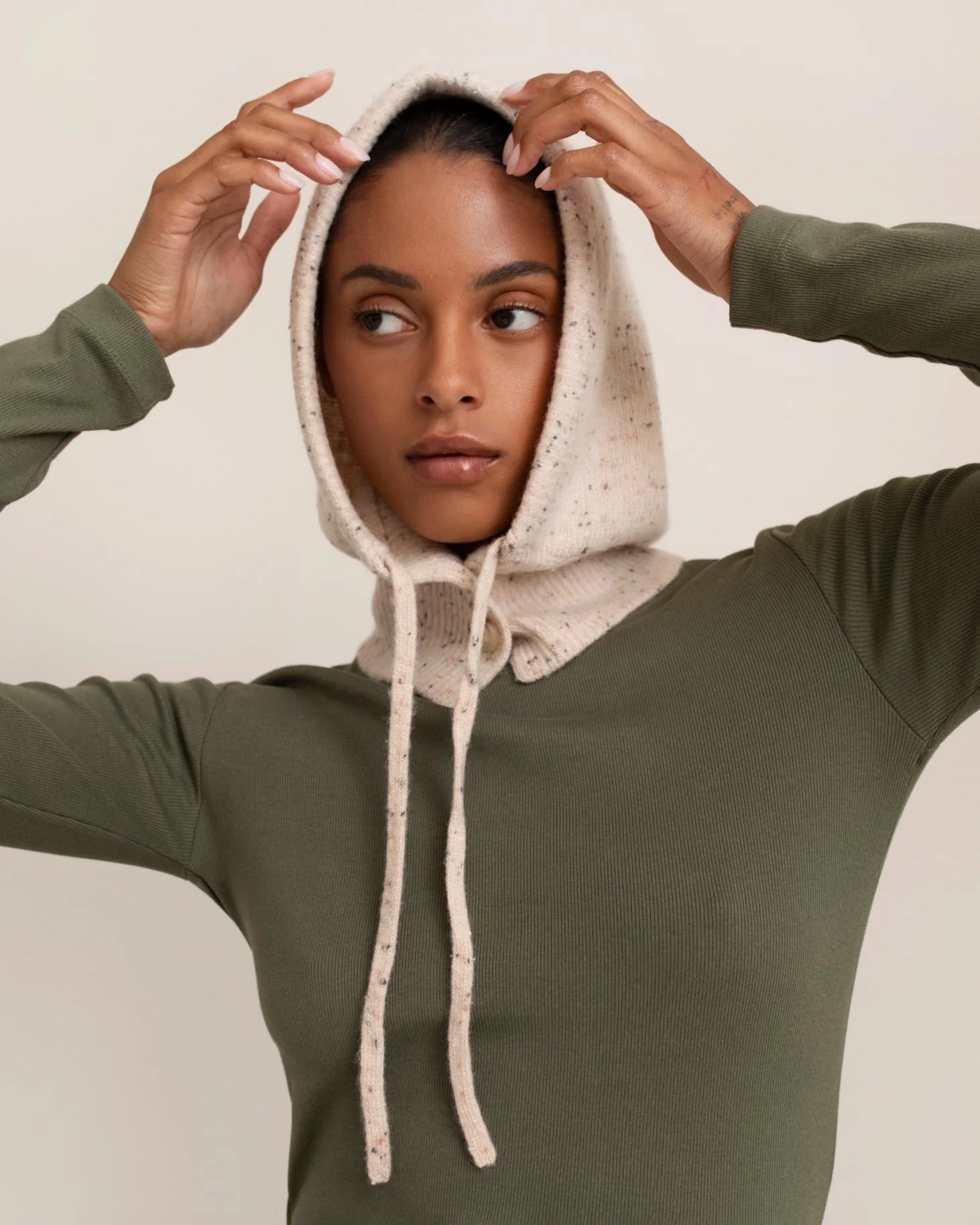 woman wearing a light cream knitted hood hat