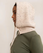 woman wearing a light cream knitted hood hat