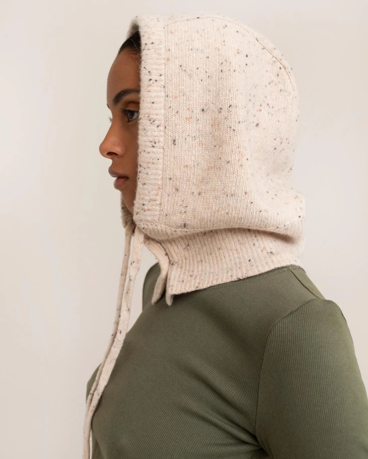 woman wearing a light cream knitted hood hat
