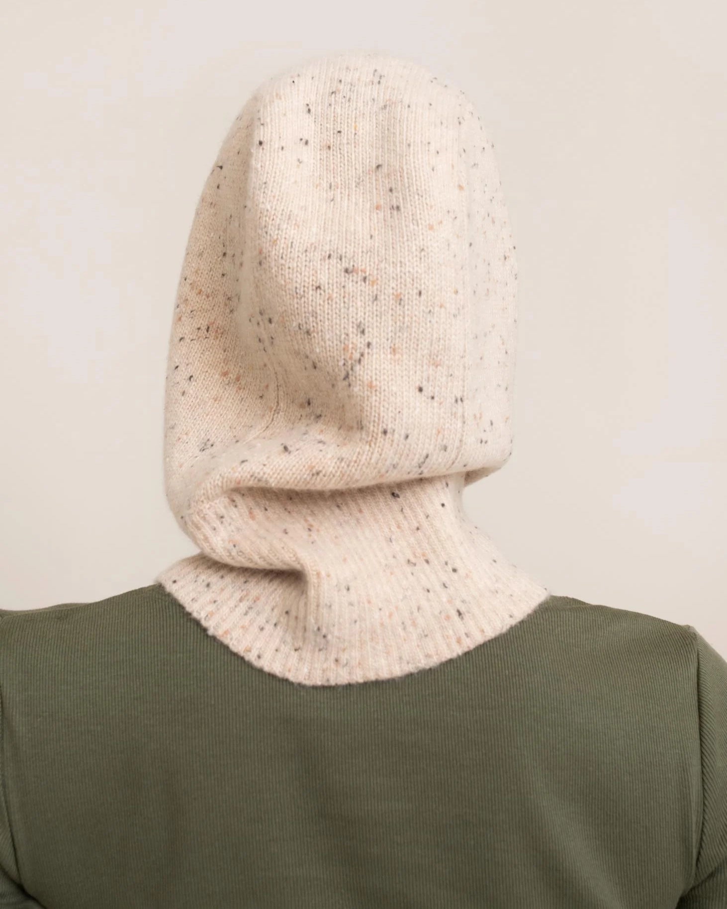 woman wearing a light cream knitted hood hat