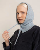 woman wearing a light blue knitted hood hat