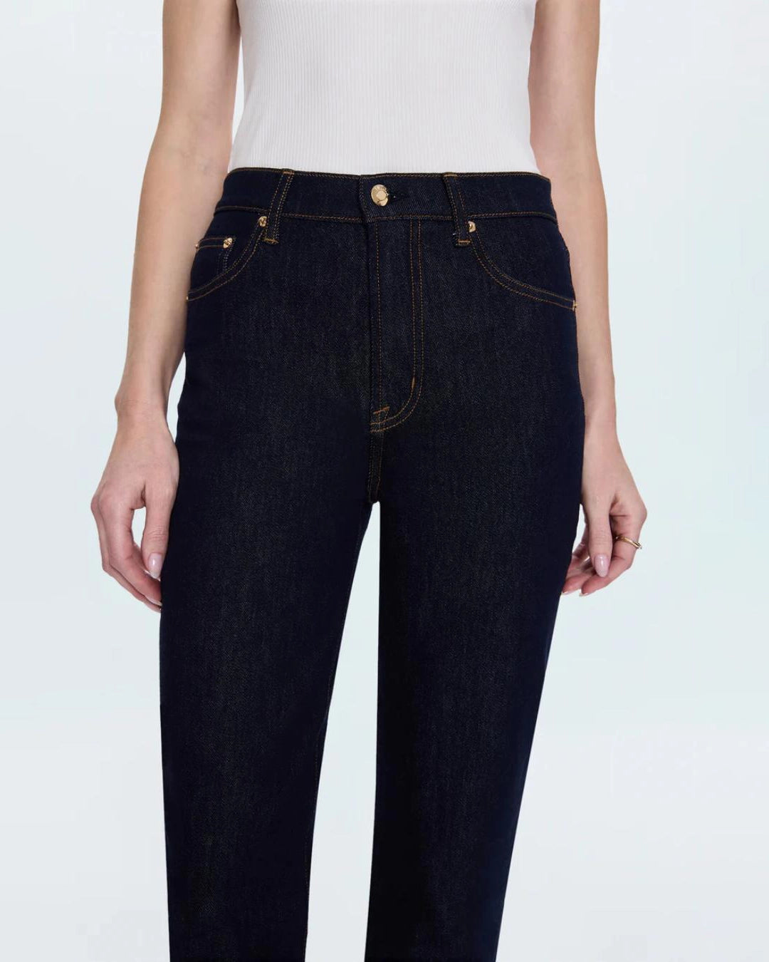 a woman wearing cropped dark wash ankle denim jeans by Pistola