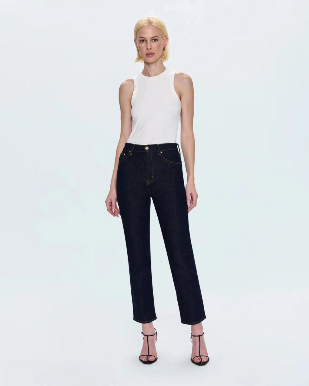 a woman wearing cropped dark wash ankle denim jeans by Pistola