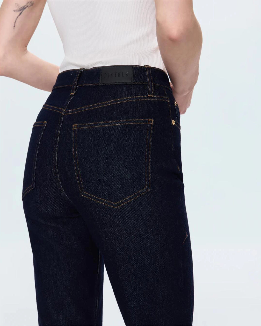 a woman wearing cropped dark wash ankle denim jeans by Pistola