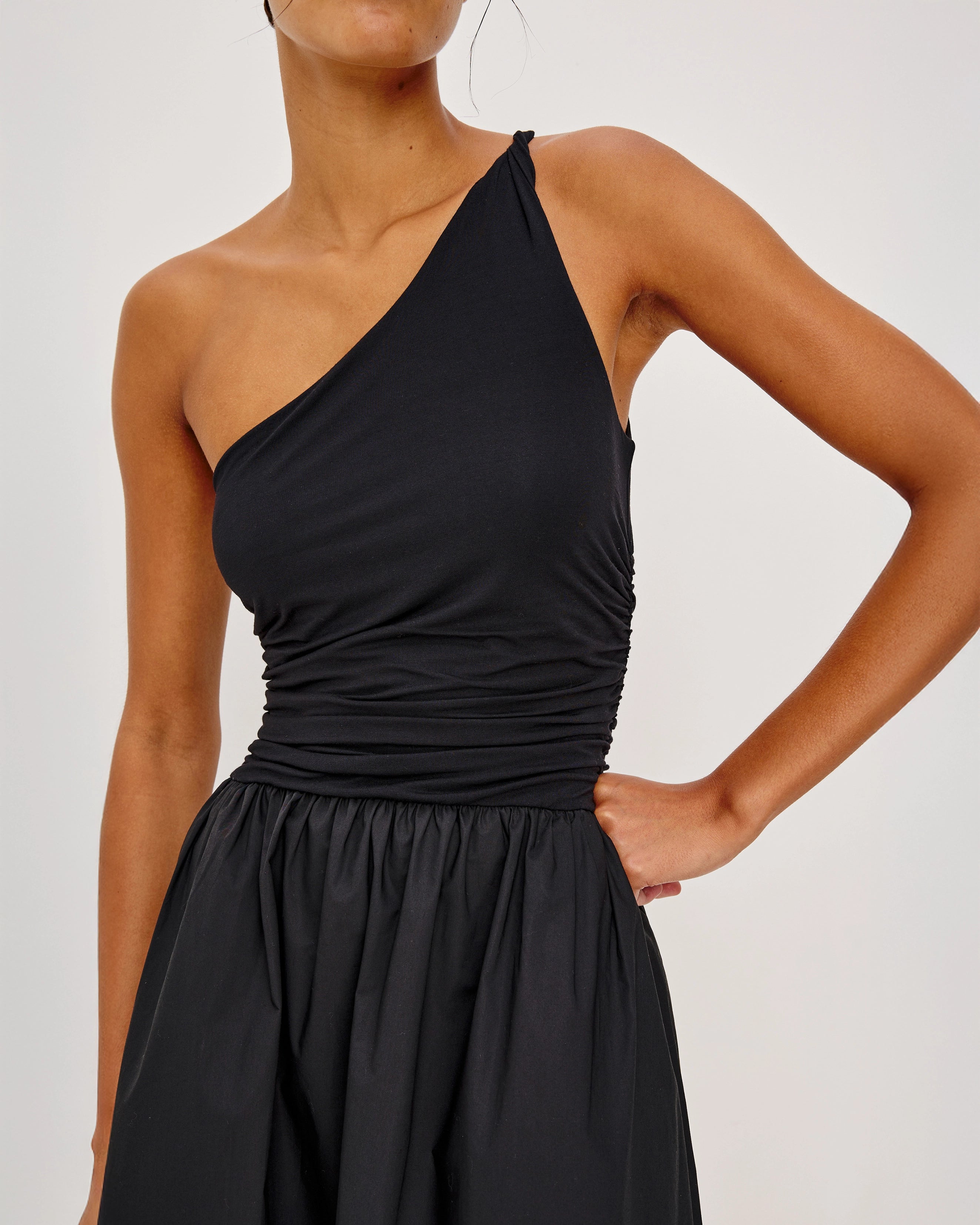 a woman wears an asymmetrical one shoulder dress in black