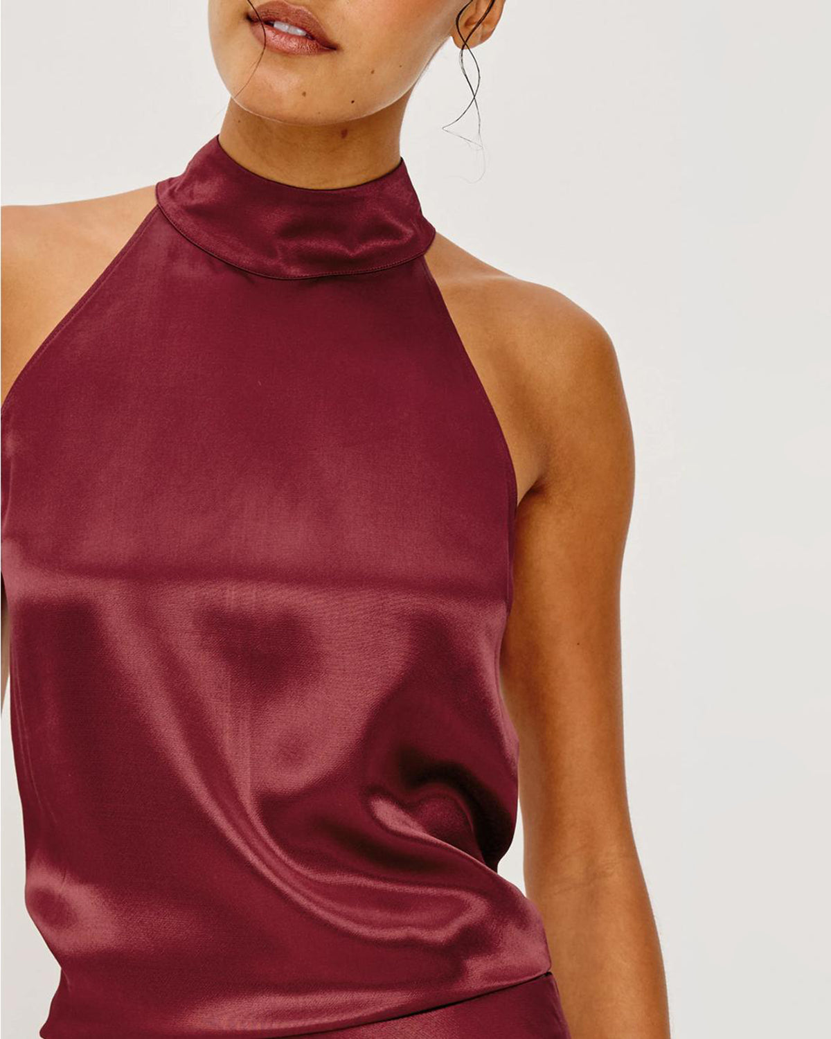 Woman wearing a burgundy satin halter top