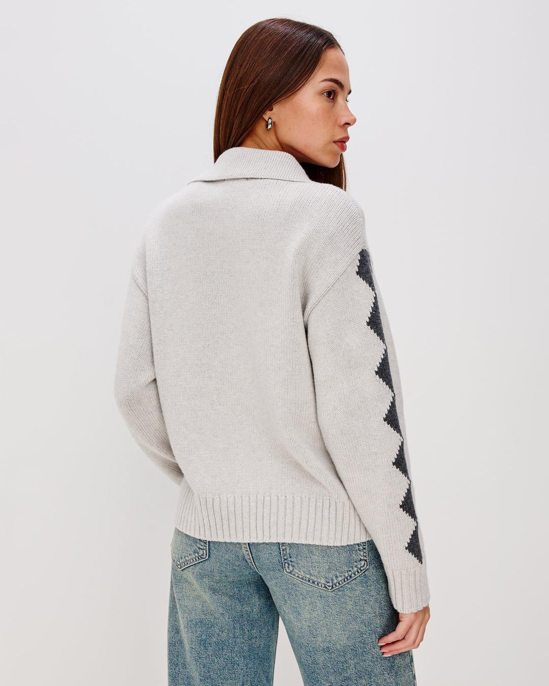 Grey zip up sweater with two skiiers on the chest in blue
