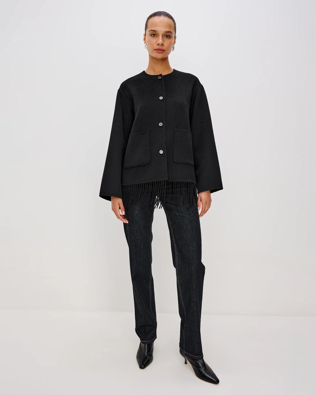 Person wearing a black jacket with fringes on the hem