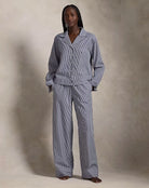 a lady wears a matching pajama set in blue stripes by ralph lauren