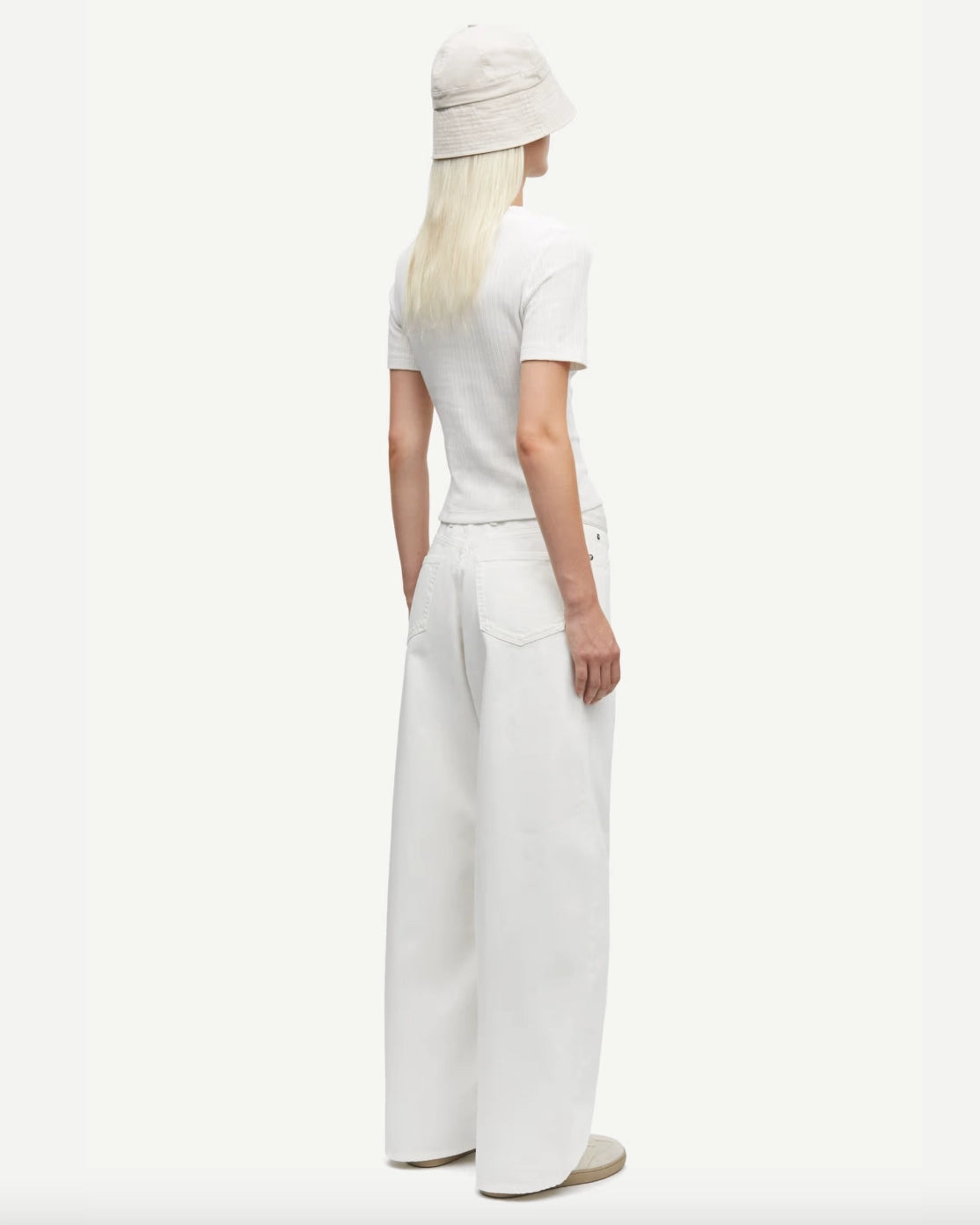 Woman wearing a white short-sleeve button down cardigan top and pants