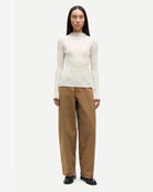 a woman wearing 100% cotton jeans with belt in khaki colour