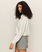 Woman wearing a white cropped zip jacket