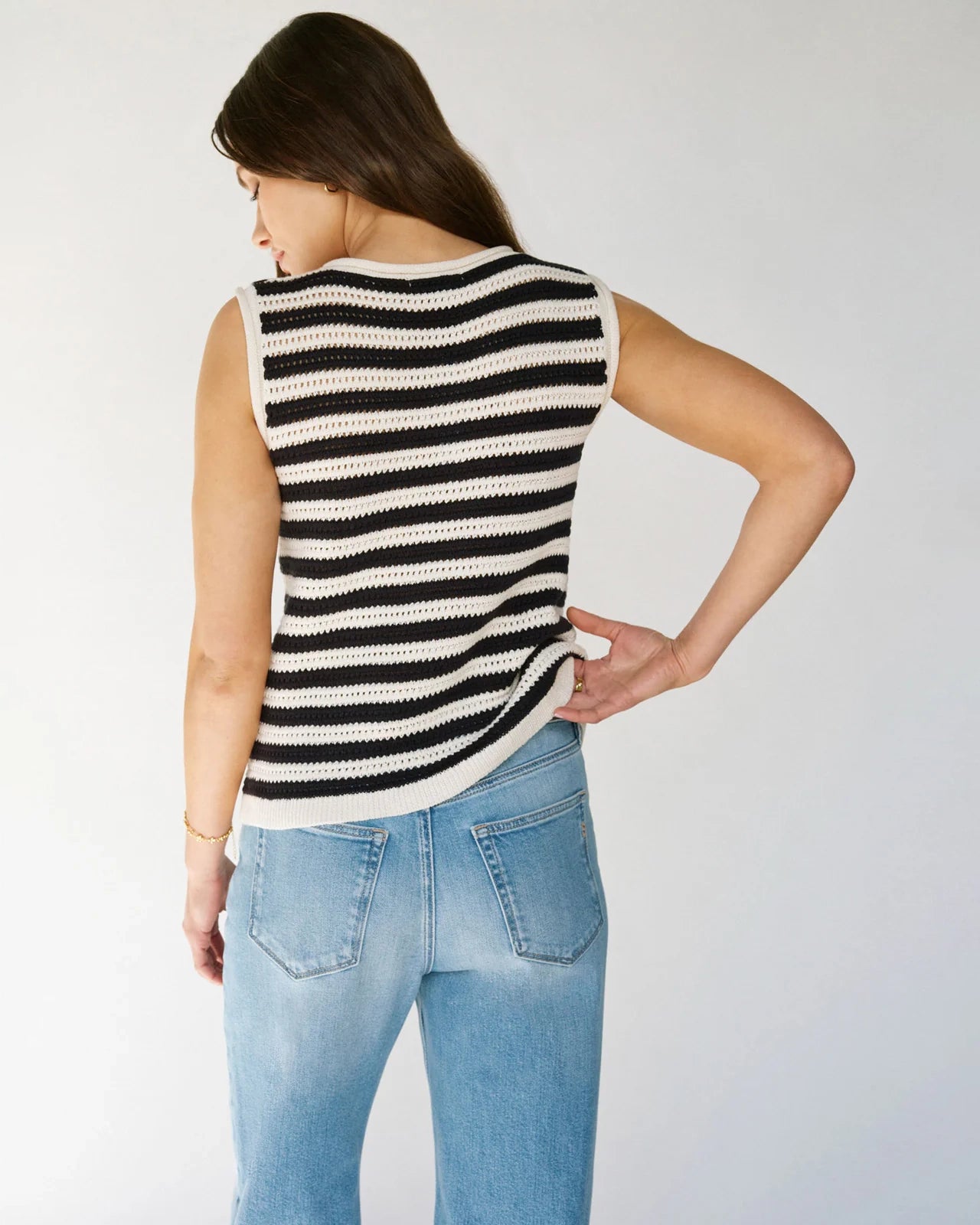 Woman wearing a crochet knit black and white striped sleeveless top