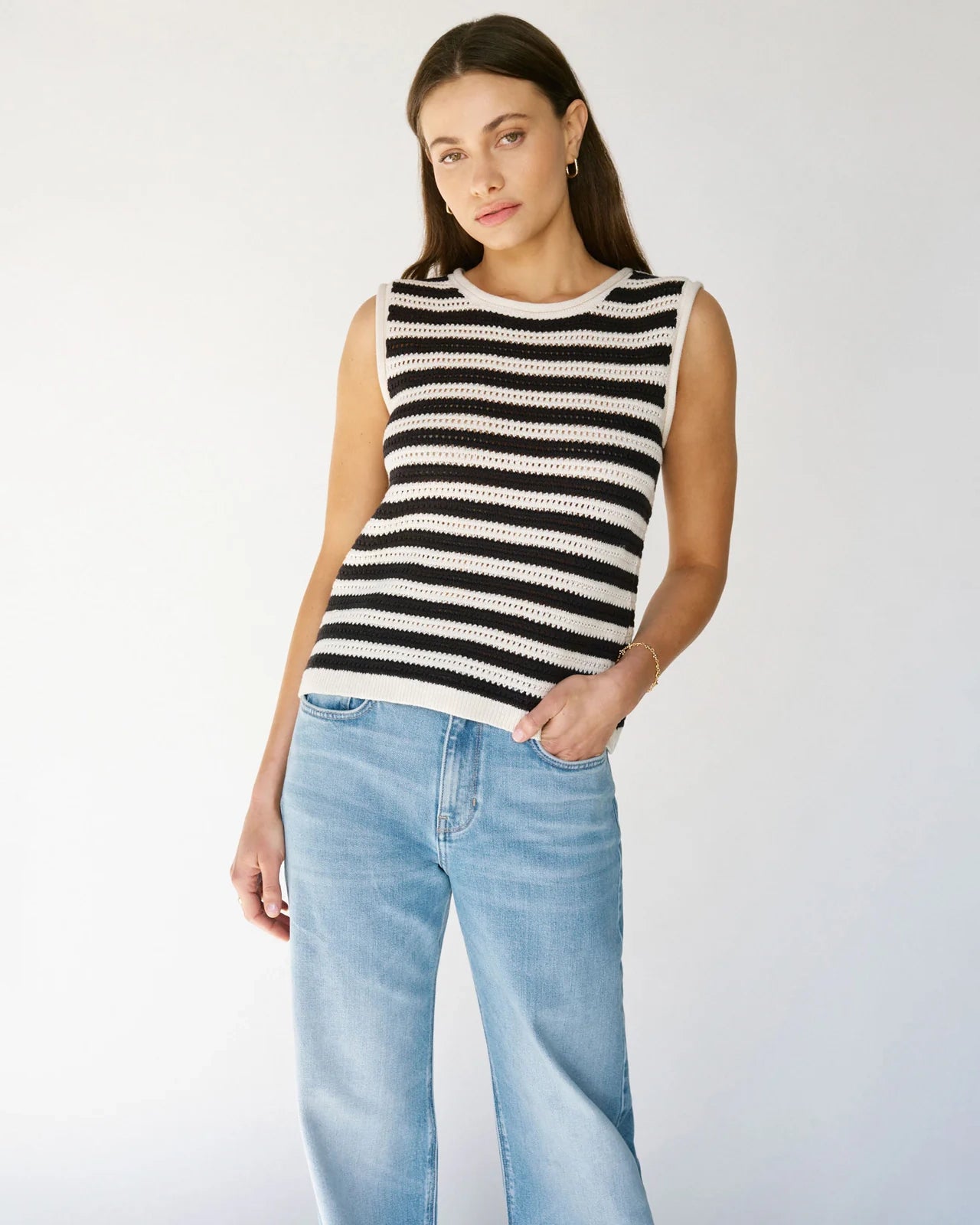 Woman wearing a crochet knit black and white striped sleeveless top