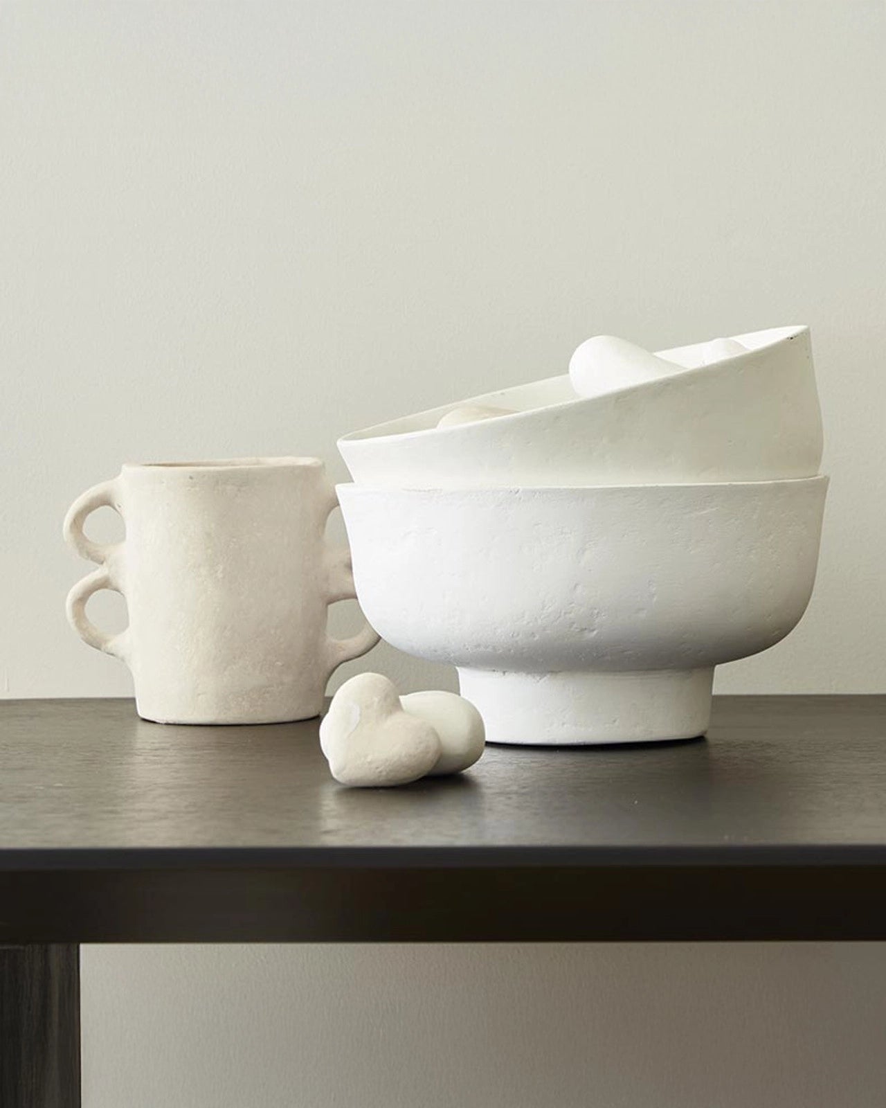 Santa Barbara Design Paper Mache Large White Bowl stacked with a vase and paper mache hearts to the side