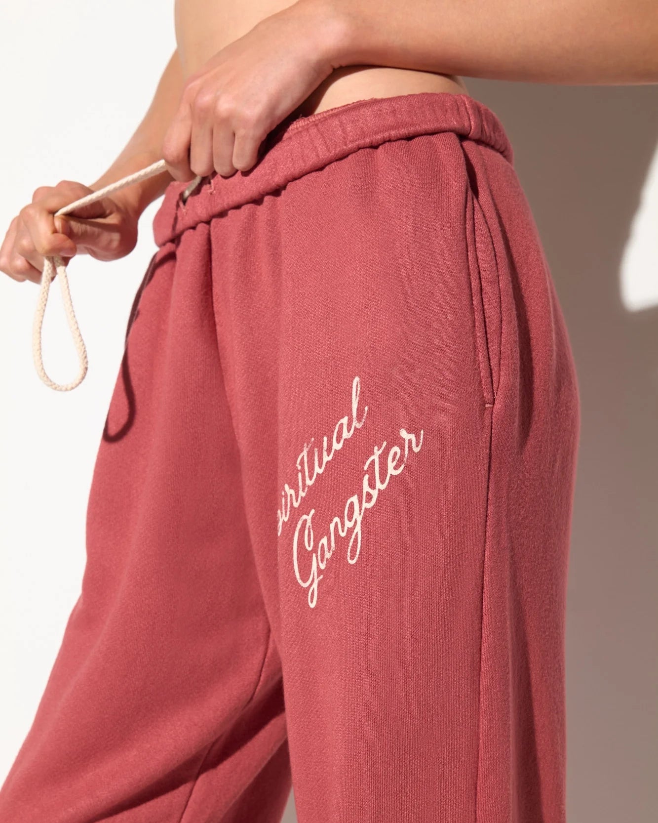 Rust coloured sweatpants with 'Spiritual Gangster' text on them