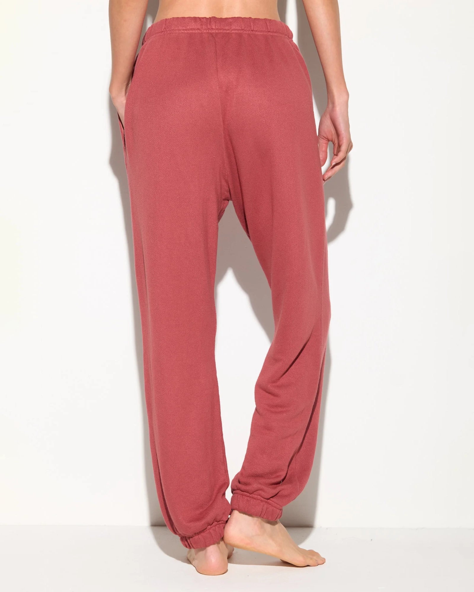 Rust coloured sweatpants with 'Spiritual Gangster' text on them