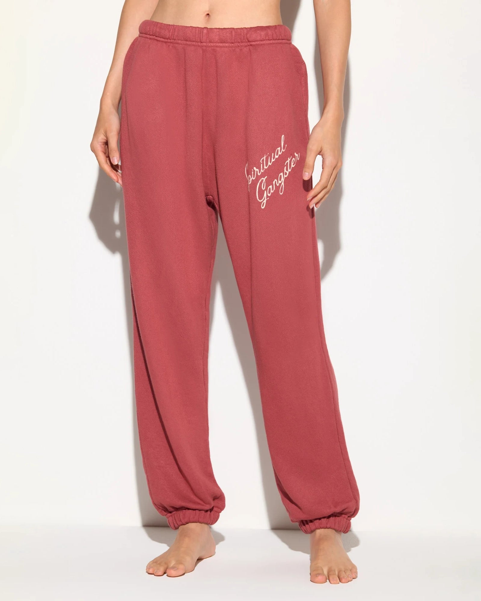 Rust coloured sweatpants with 'Spiritual Gangster' text on them