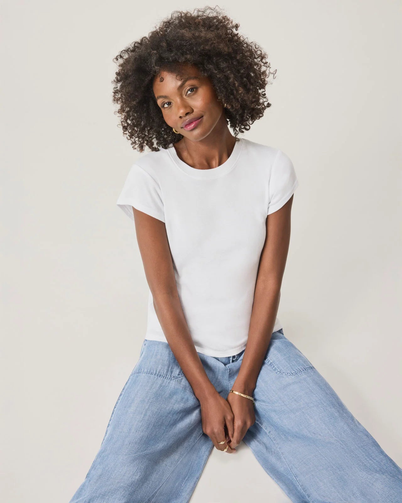 a woman wearing a classic crew neck white tshirt
