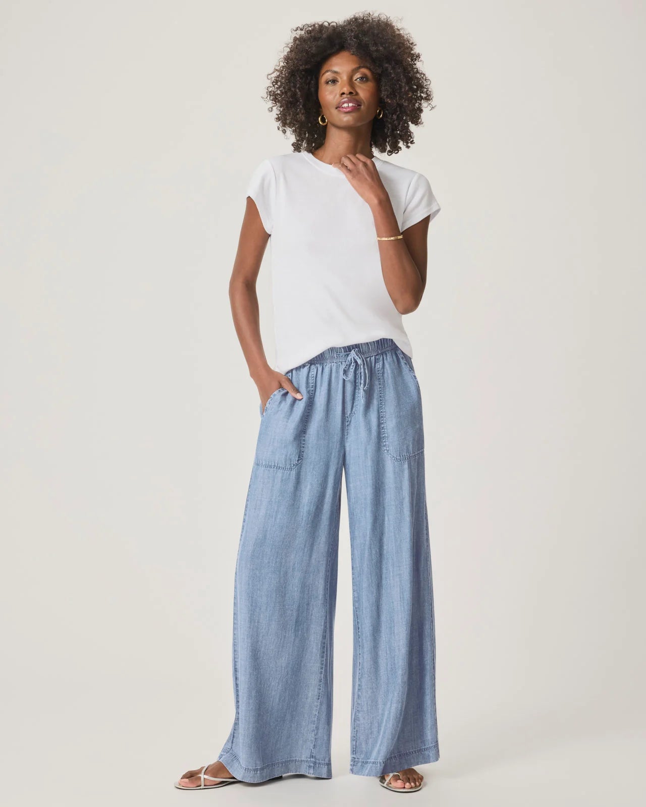 a woman wearing a classic crew neck white tshirt and jean trousers